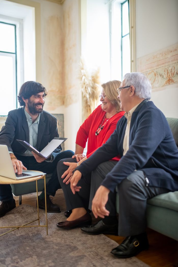 why-choose-us A professional business consultation with a senior couple and advisor indoors.